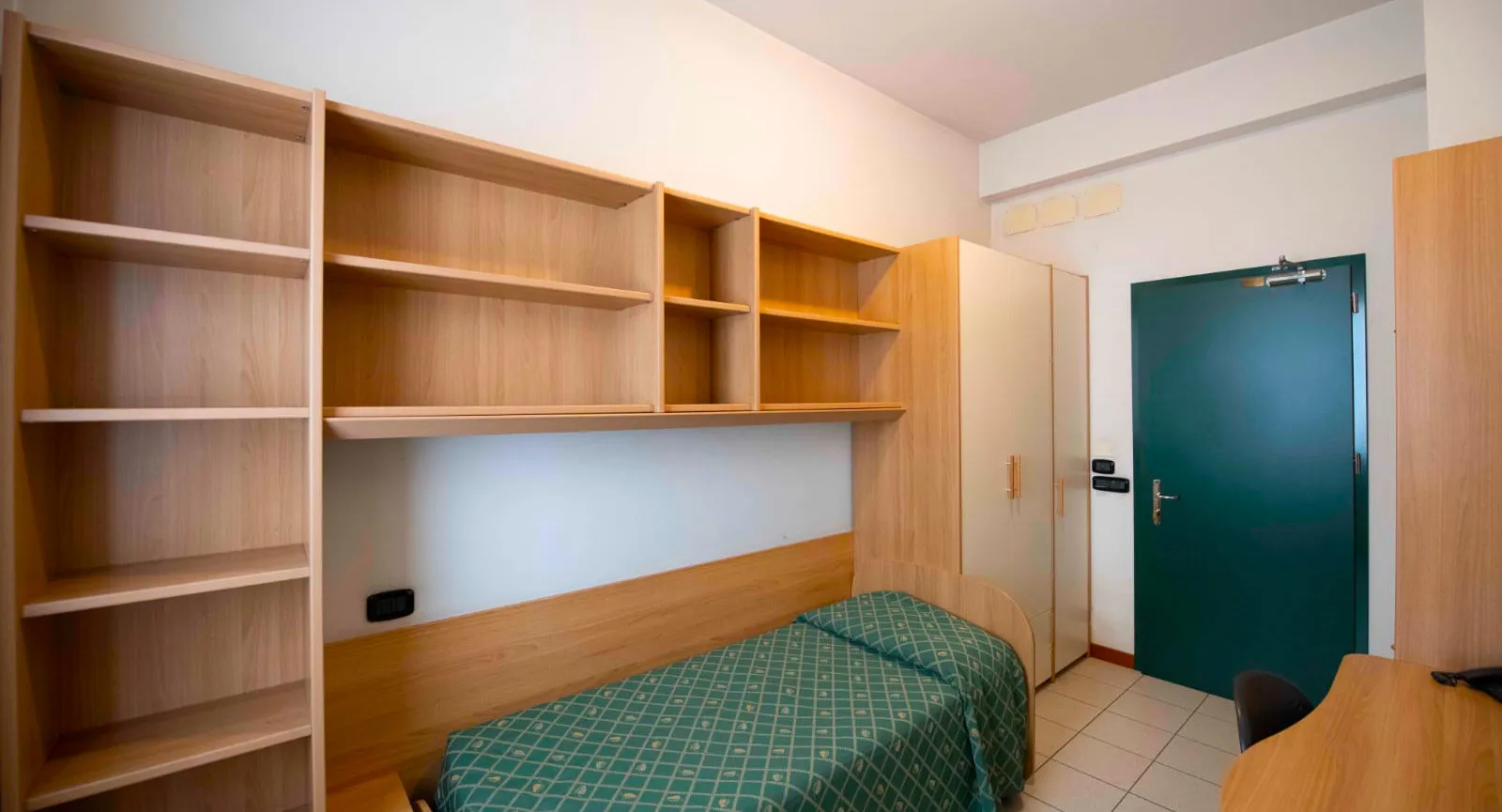 Stanza singola armadio e libreria con mensole e letto