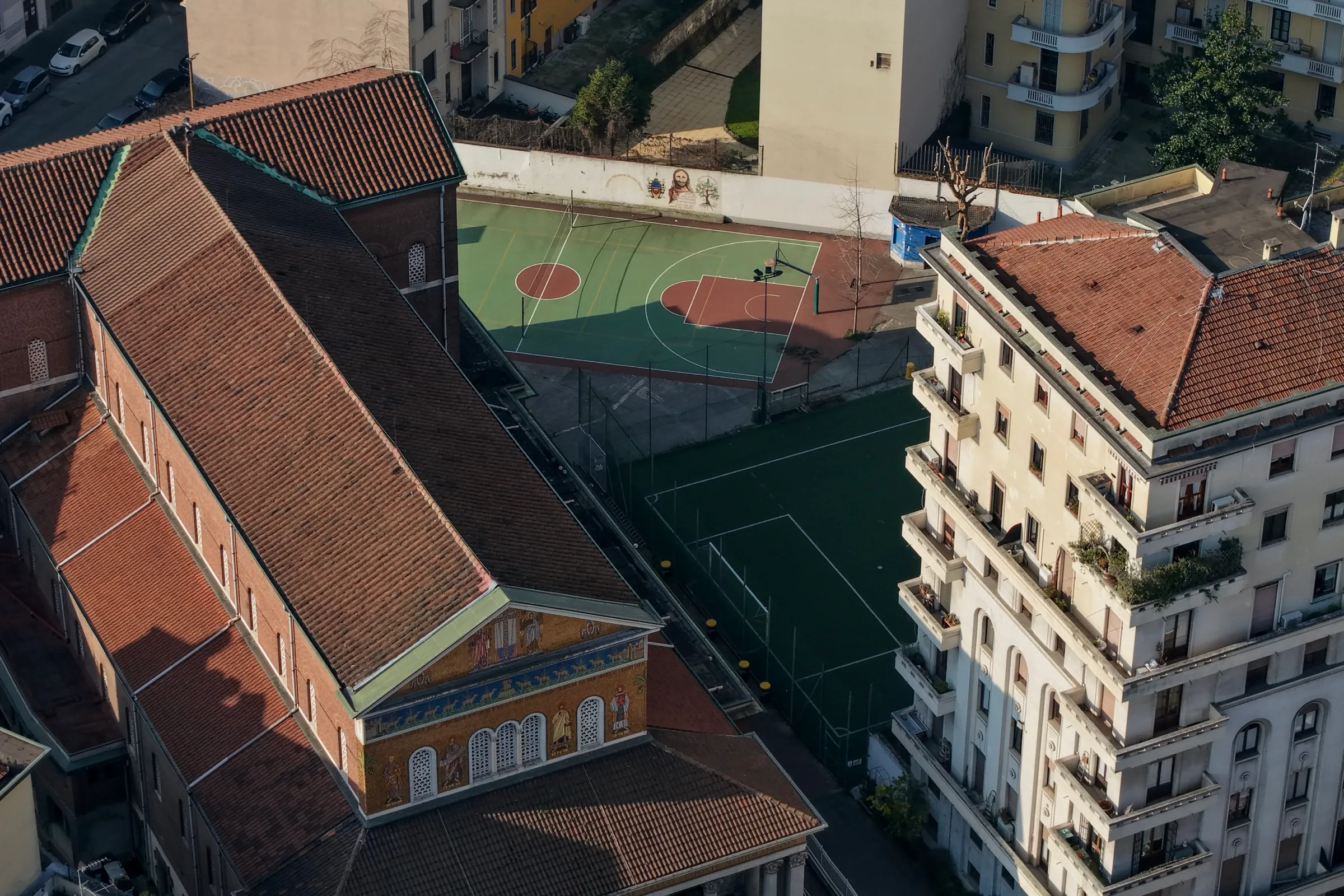 Vista alternativa dei campi sportivi con la chiesa sullo sfondo