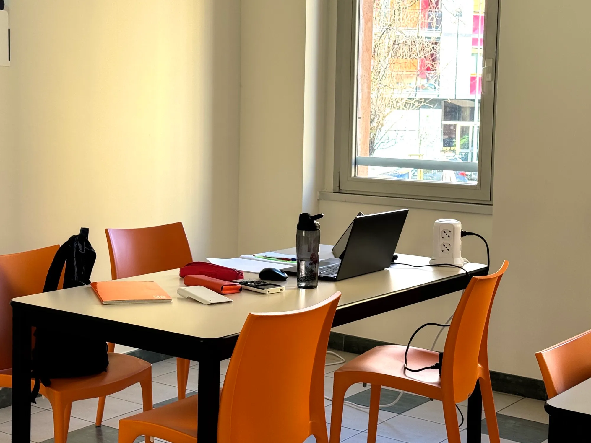 Postazione studio con scrivania, laptop e ciabatta elettrica